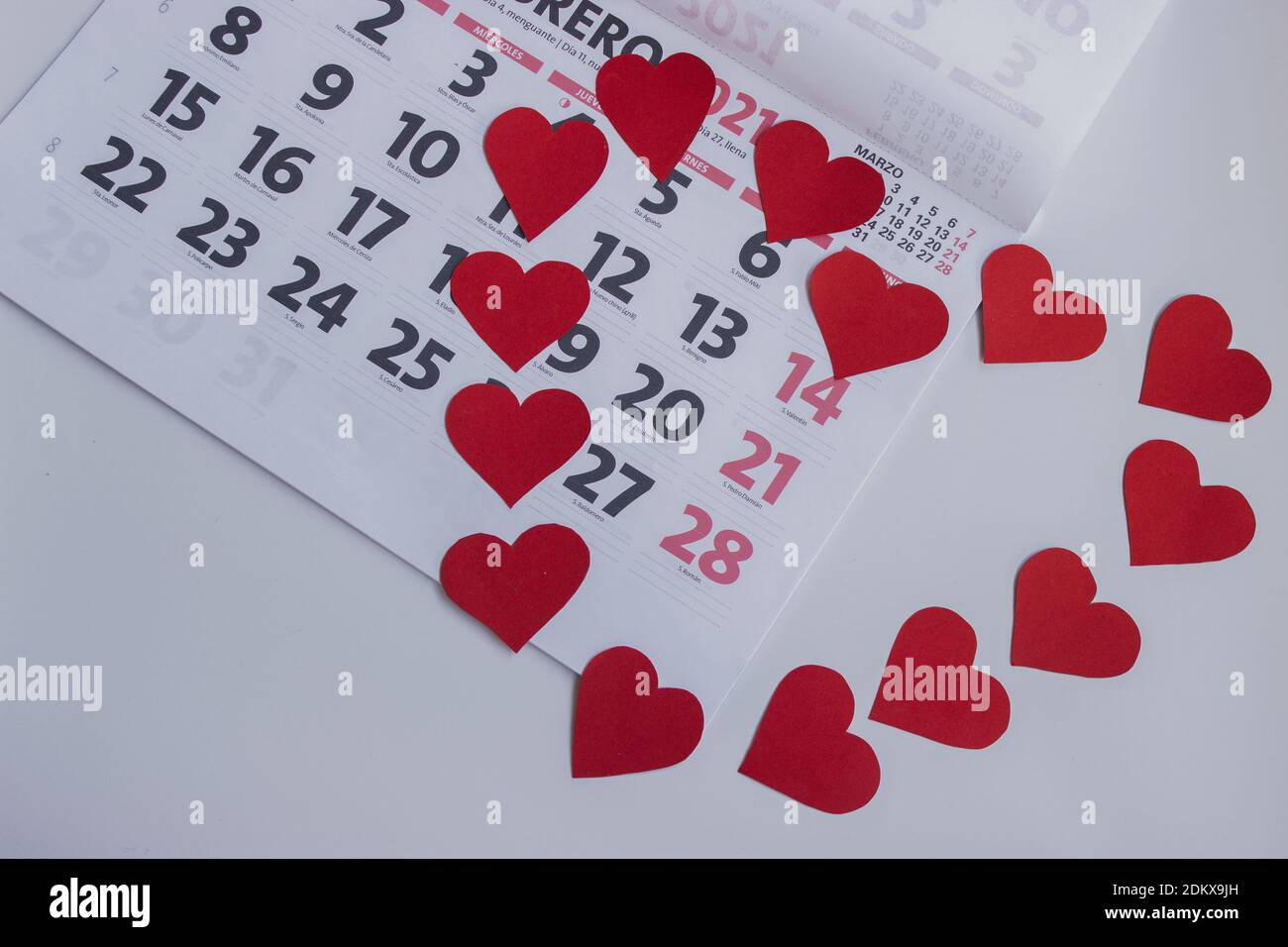 Imagen conceptual de 2021. Conjunto de corazones formando una forma de corazón en el calendario del 2021 de febrero alrededor del día de San Valentín. 14 de febrero marcado con corazones. Foto de stock