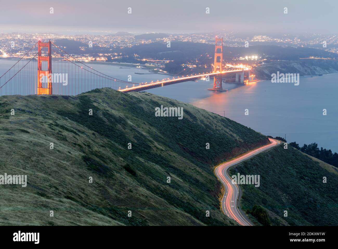 Senderos de luz para coches y el puente Golden Gate Glowing por la noche Foto de stock