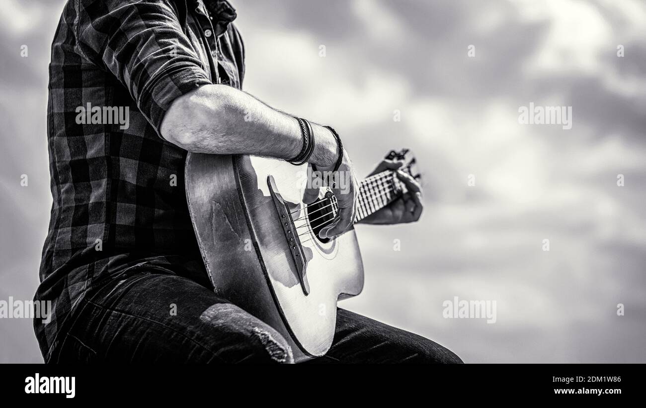Manos del hombre tocando guitarra acústica, de cerca. Guitarras acústicas  tocando. Concepto de música. Blanco y negro Fotografía de stock - Alamy