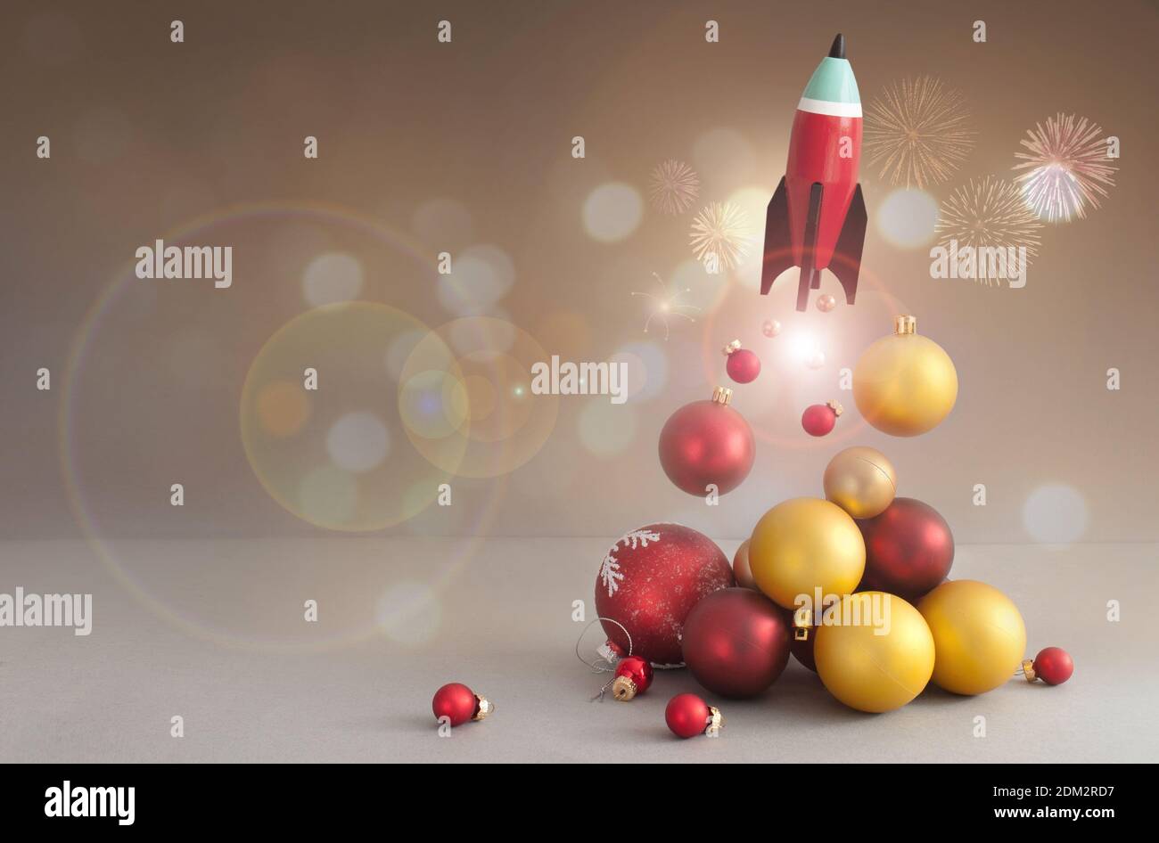 Cohete de juguete despegue, con bolas de Navidad rojas y doradas Foto de stock