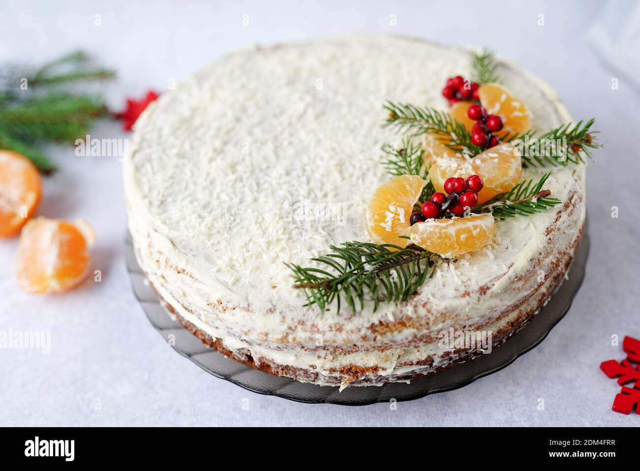 Comida de Navidad pastel de fruta, cubierto de verdor de invierno, bayas decorativas y tangerinas Foto de stock