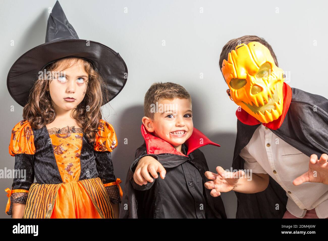 Hermanos en el traje de Halloween de pie contra la pared Fotografía de  stock - Alamy