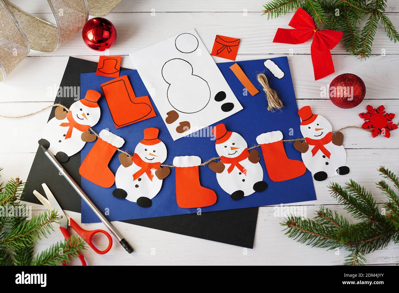 Hacer guirnalda de Navidad con muñecos de nieve de papel. Proyecto de arte  para niños. DIY concepto. Foto instrucción Fotografía de stock - Alamy