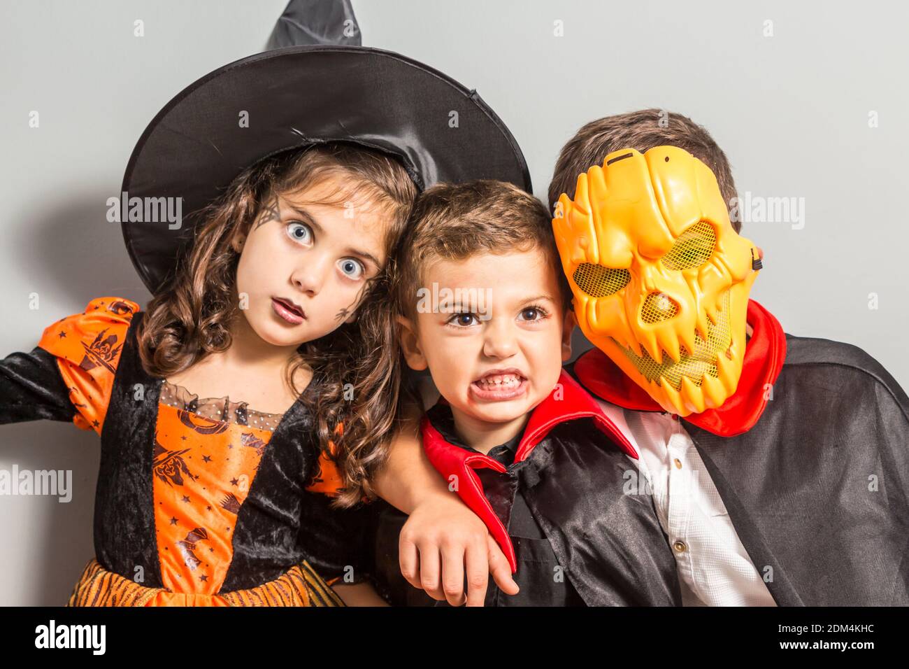Hermanos en el traje de Halloween de pie contra la pared Fotografía de  stock - Alamy