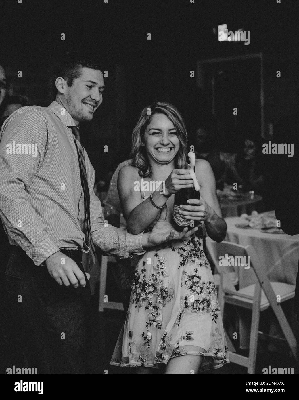 Champaña de apertura para una pareja feliz en el restaurante Foto de stock