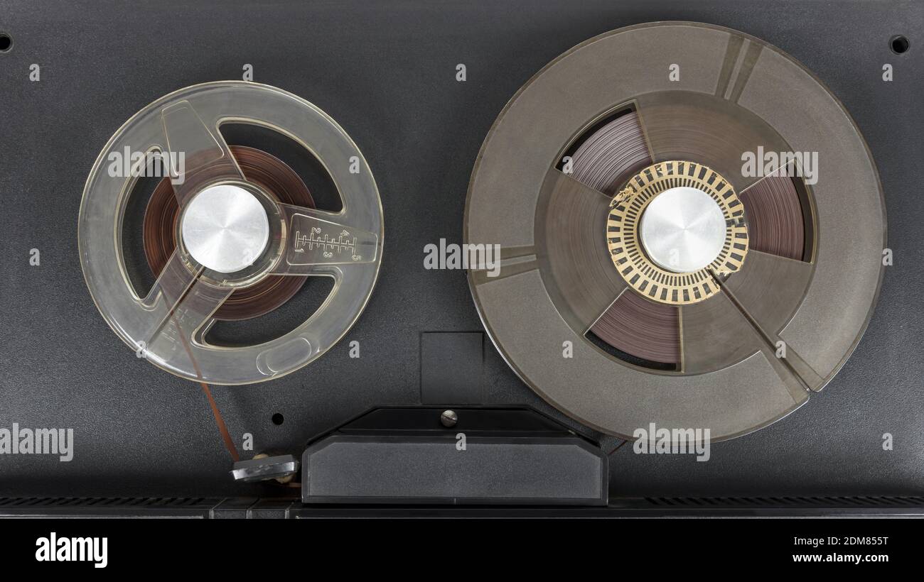 Cierre de los viejos carretes de cinta de audio montados en la cinta grabadora Foto de stock