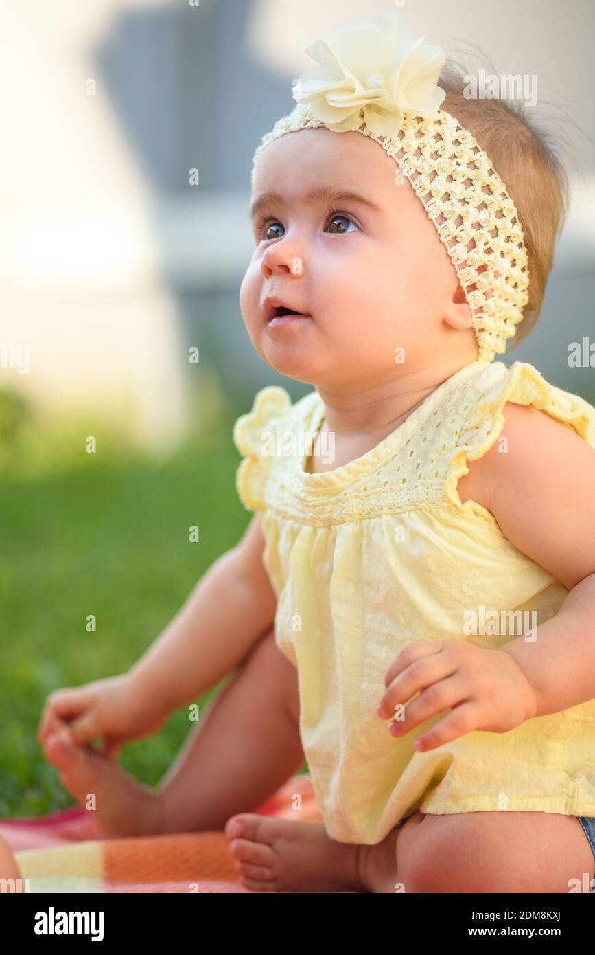 Chica linda con ropa de bebé amarilla en el patio trasero Fotografía de  stock - Alamy
