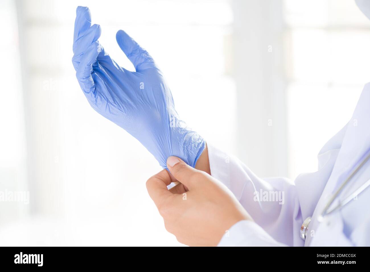 Doctora con un estetoscopio en un hombro poner guantes estériles. Concepto  de salud y medicina Fotografía de stock - Alamy
