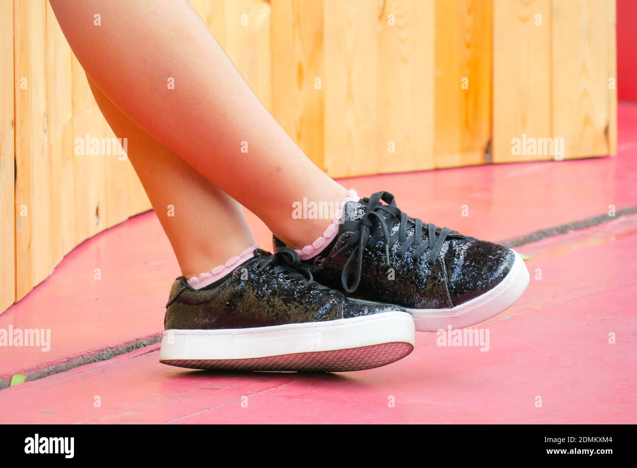 La sección baja de la mujer que usa zapatos negros mientras que está parado  en el piso Fotografía de stock - Alamy