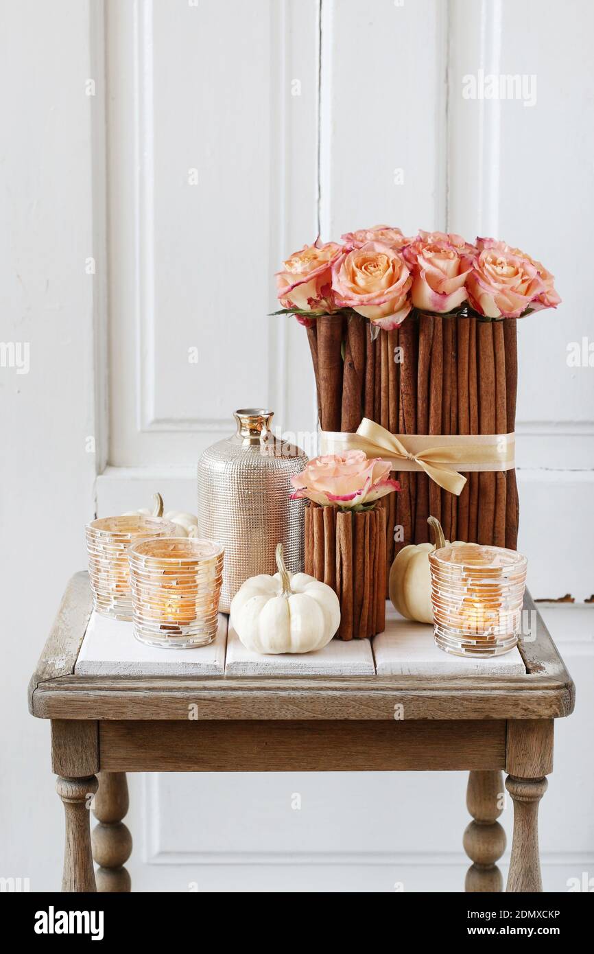 Arreglo floral con rosas y bastones de canela se pone sobre la mesa.  Decoración de fiesta Fotografía de stock - Alamy