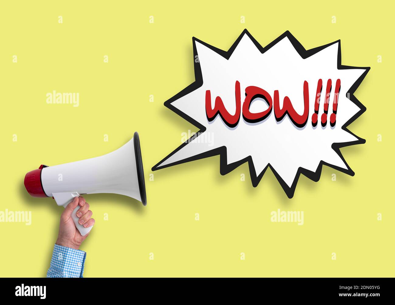 Mano sosteniendo megáfono y burbuja de discurso con texto WOW en contra fondo amarillo Foto de stock