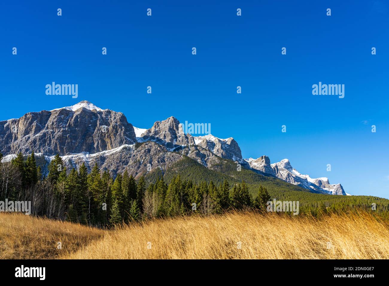 Parque Quarry Lake, playa serena en la ladera de la montaña y parque para perros a finales de la temporada de otoño soleado día por la mañana. Monte Rundle cubierto de nieve con cielo azul Foto de stock