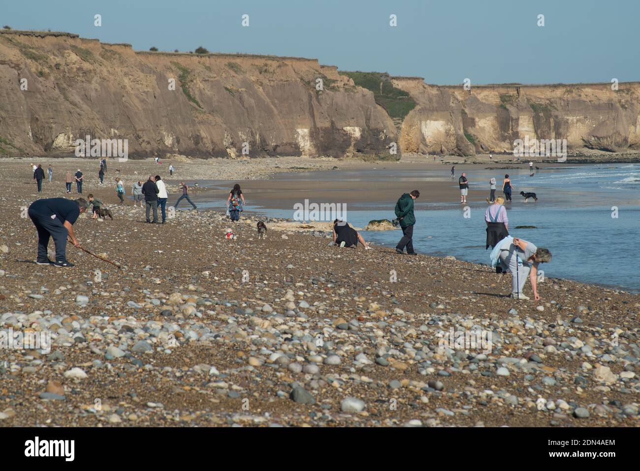 Vista de la playa en Seaham con gente buscando piezas de vidrio de mar que se pueden utilizar para ornamentos, joyas de vestuario y artesanía Foto de stock