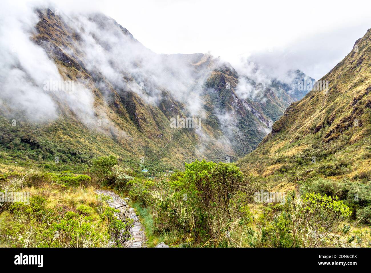 Montañas envueltas en nubes y niebla a lo largo del camino Inca a Machu Picchu, Valle Sagrado, Perú Foto de stock