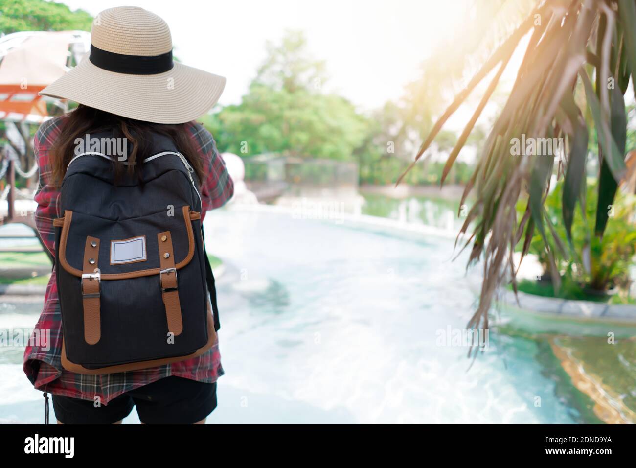 Vista trasera de la mujer con mochila de pie junto a la piscina contra los  árboles Fotografía de stock - Alamy