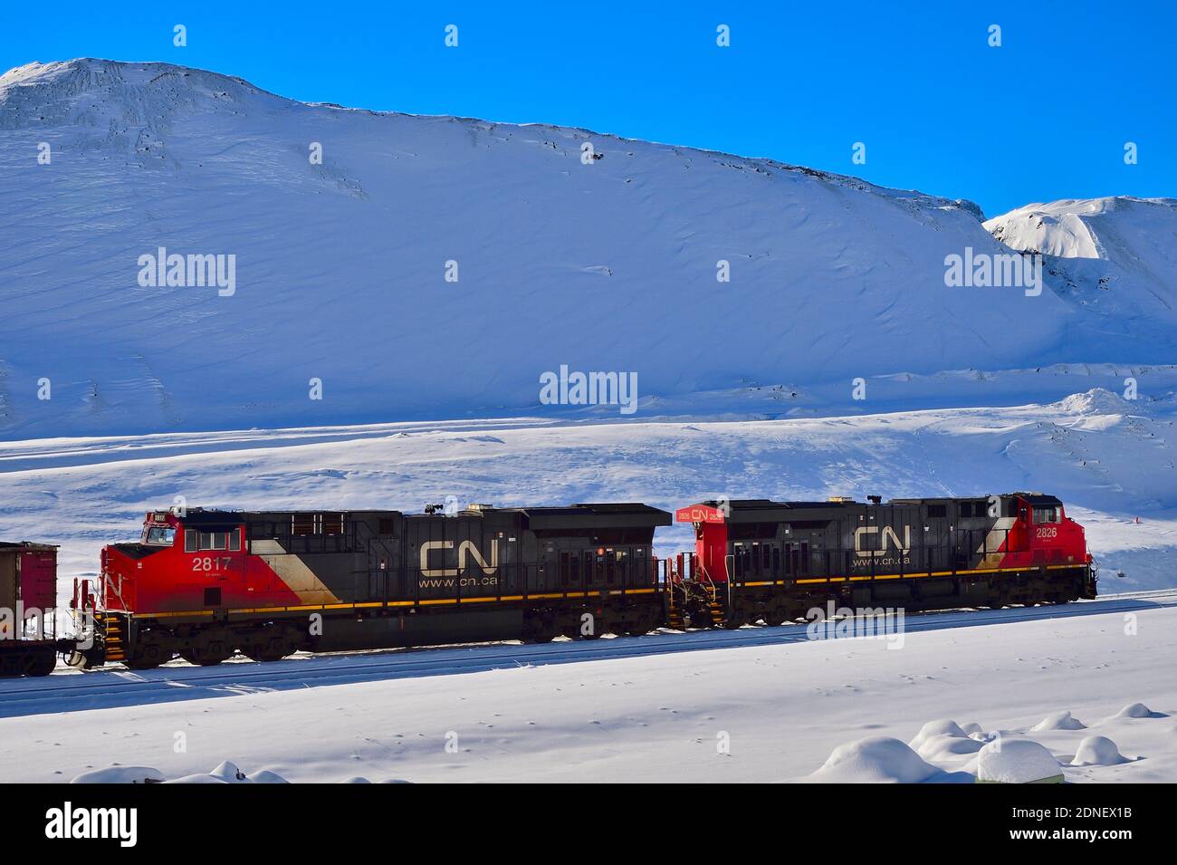 Motores de trenes nacionales canadienses esperando en una vía de trenes en la nieve profunda del invierno en las zonas rurales de Alberta, Canadá. Foto de stock