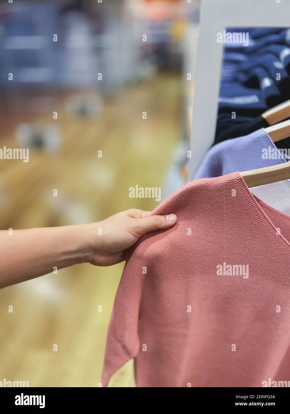 Mano de mujer recortada Ropa de golf en la tienda de ropa Fotografía de  stock - Alamy