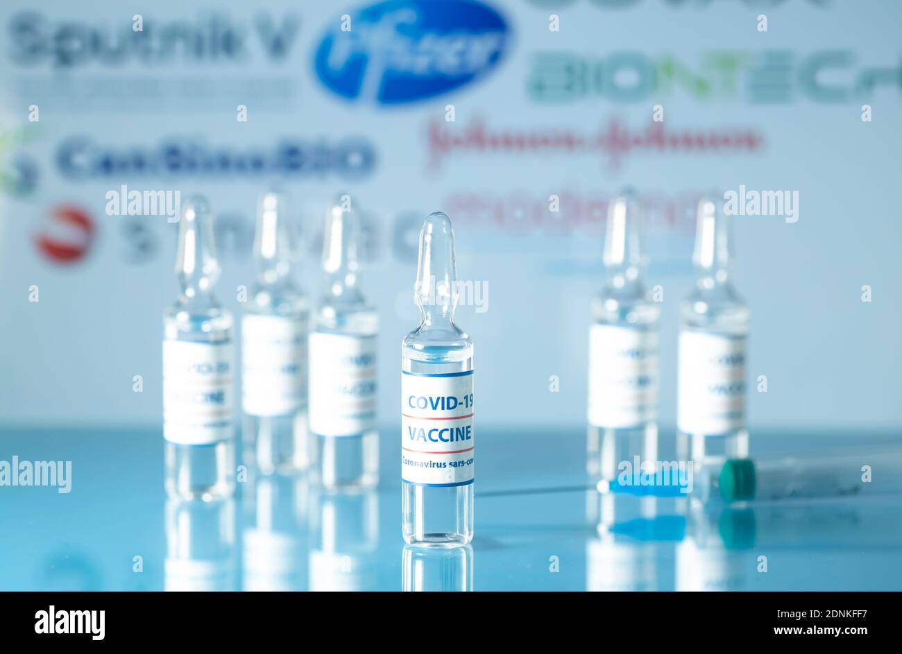 Empresas fabricantes de vacunas contra COVID-19. Viales médicos de vidrio con líquido en los logotipos de fondo de la empresa. Ampollas con vacuna contra coronavirus o Foto de stock