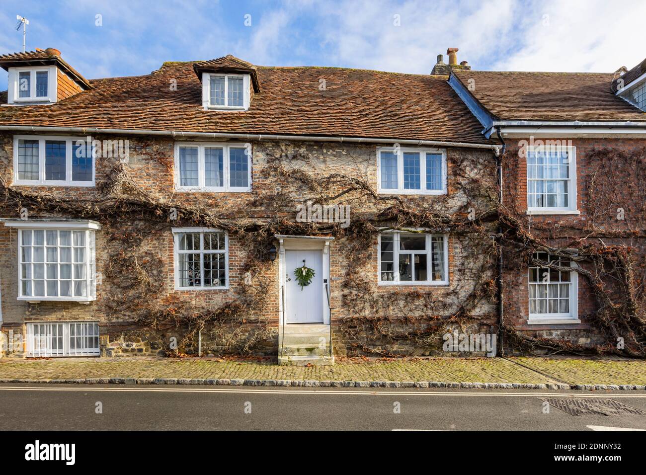 Casa de campo de estilo georgiano en Church Hill, Midhurst, West Sussex, en invierno con una corona de temporada en su puerta blanca Foto de stock