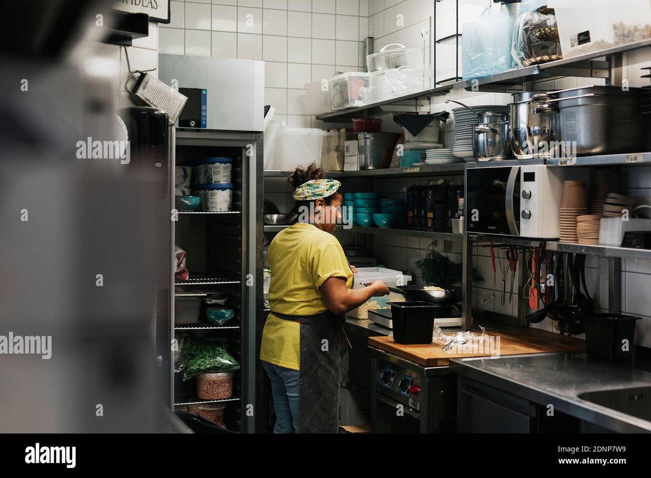 Mujer trabajando en la cocina del café Foto de stock