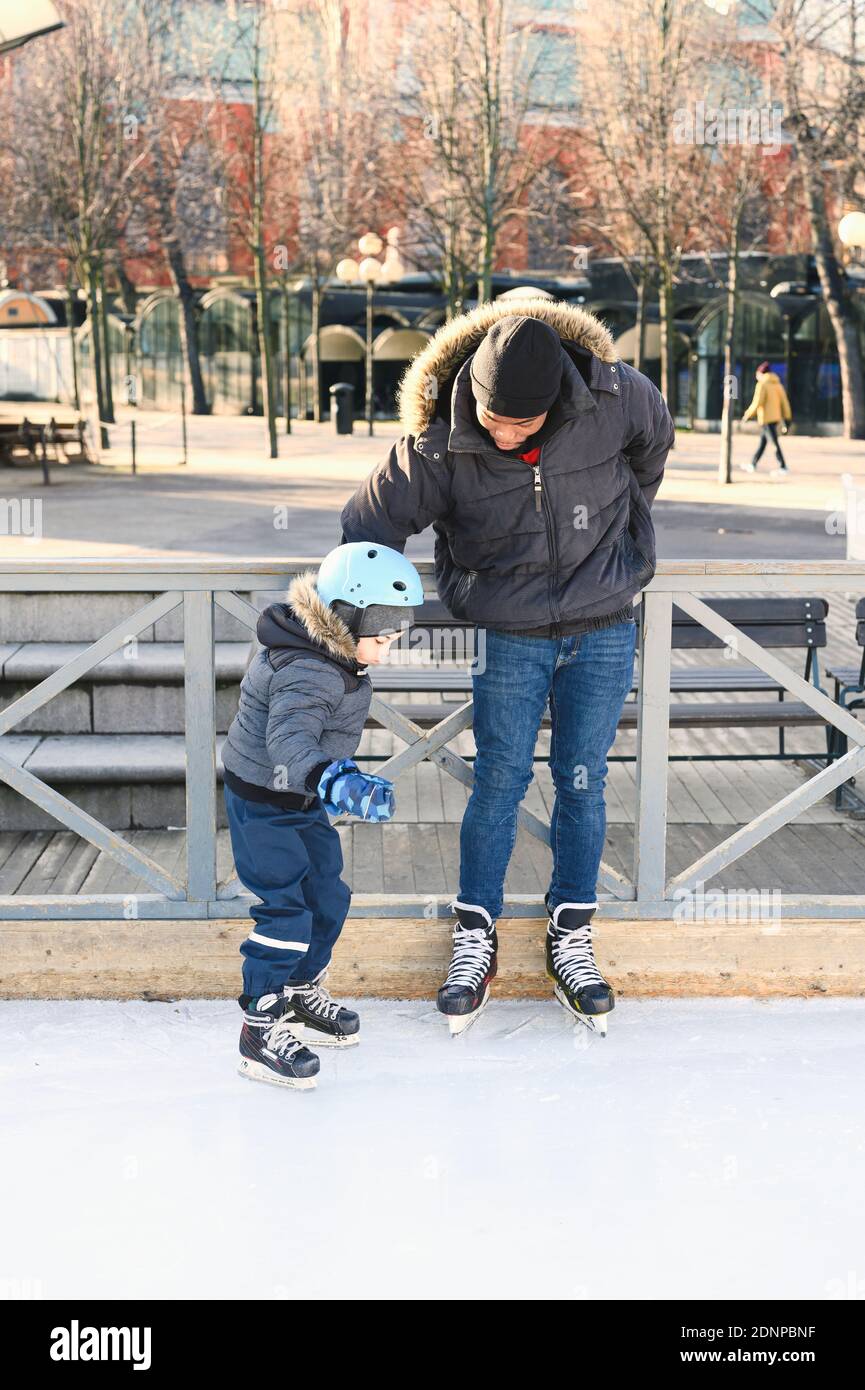 Padre enseñando patinaje sobre hielo Foto de stock