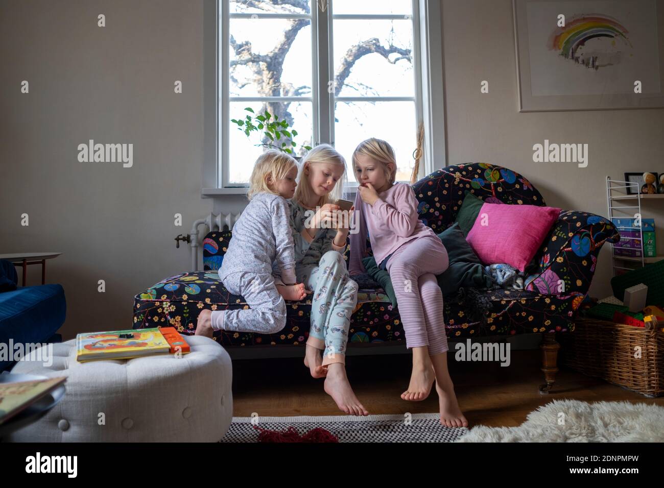 Hermanas sentado en el sofá Foto de stock