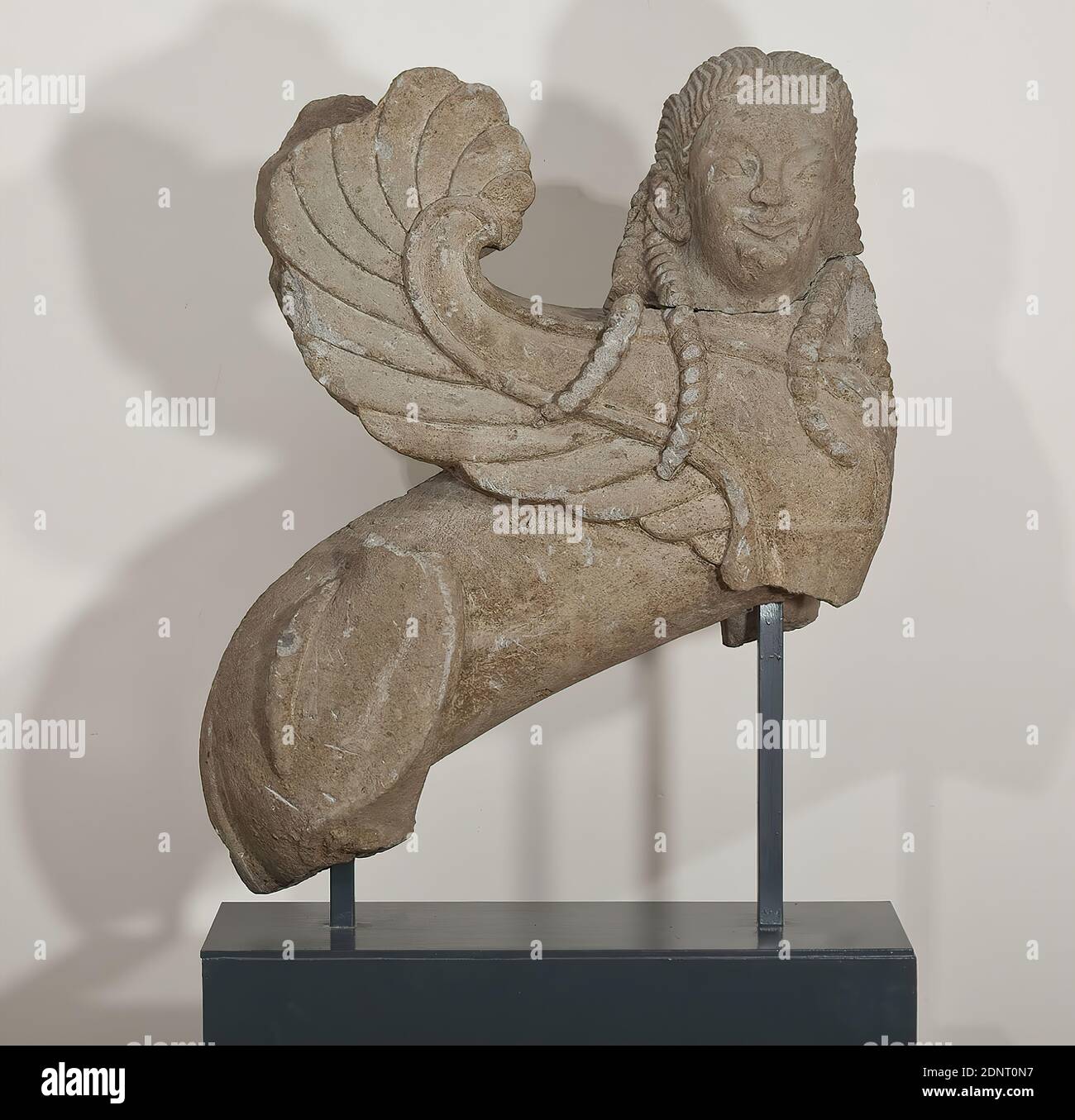 Esfinge, Tuff, cincelado, Tuff Nenfro, cincelado, total: Altura: 100.00 cm; ancho: 85.00 cm; profundidad: 33.00 cm, esculturas, monumento funerario, mobiliario funerario, Esfinge, la 'Esfinge de Hamburgo' en el esquema común de asientos griegos es uno de los mejores ejemplos de escultura arcaica etrusca preservada. El cuerpo cilíndrico del león del poderoso híbrido se muestra en el perfil, mientras que la cabeza en forma humana mira al observador frontally. Las alas están curvadas hacia arriba en forma de hoz, la cola está curvada alrededor del muslo trasero derecho. Foto de stock