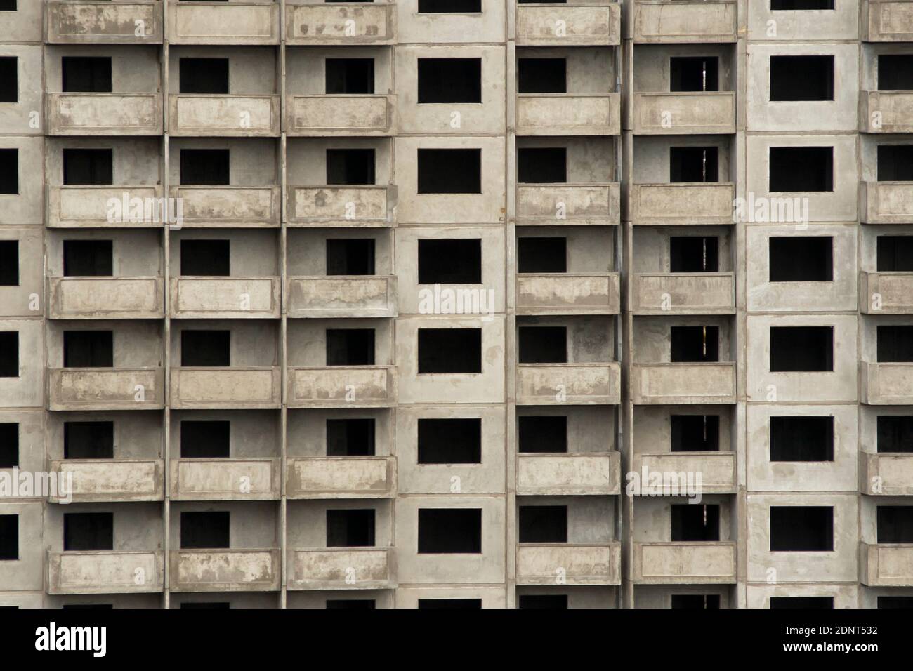 Paredes grises de edificios de apartamentos en construcción. Edificios de apartamentos de gran altura en construcción, sólo hormigón gris y ventanas abiertas Foto de stock