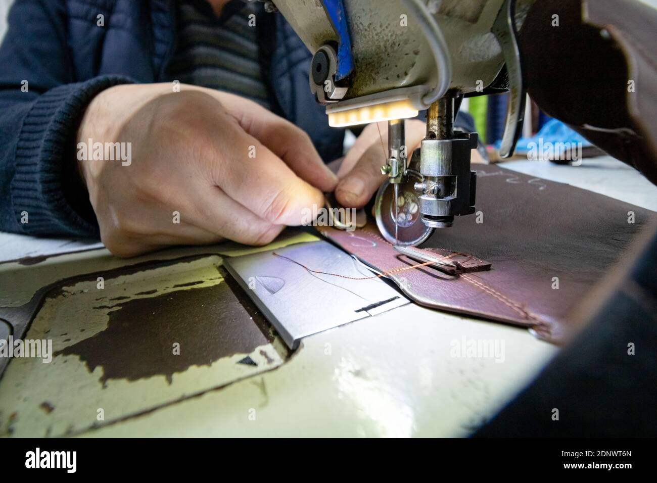 Hombre coser el cuero para hacer un zapato en la máquina de costura del  zapato en foco Fotografía de stock - Alamy