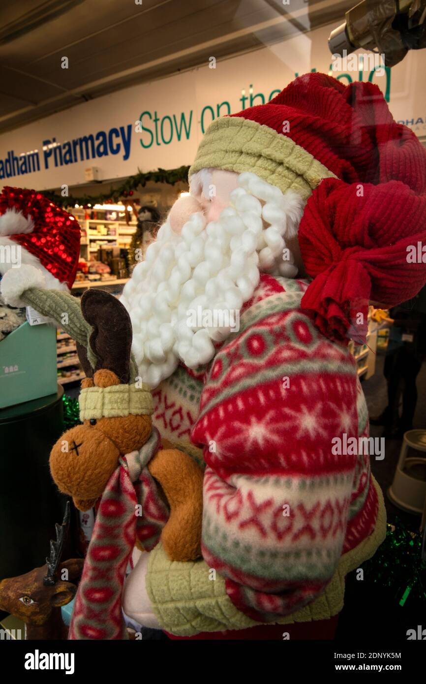 Reino Unido, Gloucestershire, Stow on the Wold, Market Square, decoraciones navideñas en la ventana de la farmacia Foto de stock