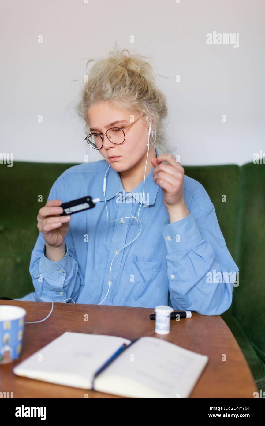 Mujer joven usando glucómetro Foto de stock