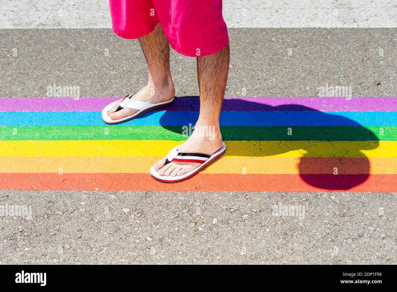 Hombre de pie en el cruce de color arco iris Foto de stock