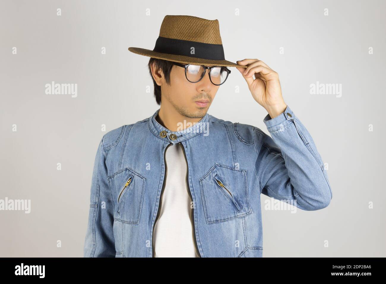 Joven Hombre asiático en vaqueros chaqueta chaqueta de dril o anteojos y  sombrero borde táctil. Chaqueta o pantalones de mezclilla de Moda Hombre  sobre fondo gris Fotografía de stock - Alamy