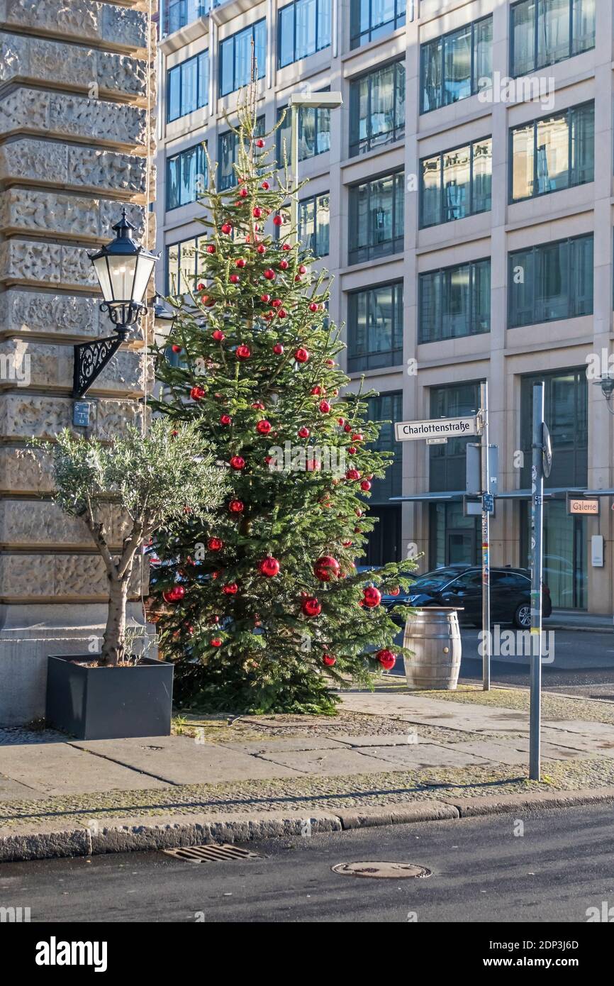 Berlín, Alemania - 18 de diciembre de 2020: Árbol de Navidad decorado con bolas rojas en la calle Behrenstrasse esquina Charlottenstrasse Foto de stock