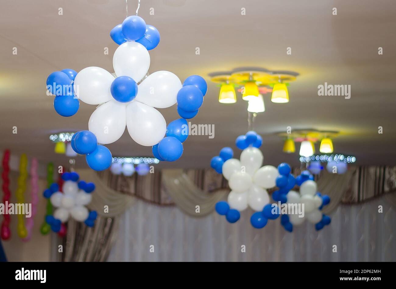 Copos de nieve de globos blancos y azules adornan el techo la sala de fiestas Foto de stock