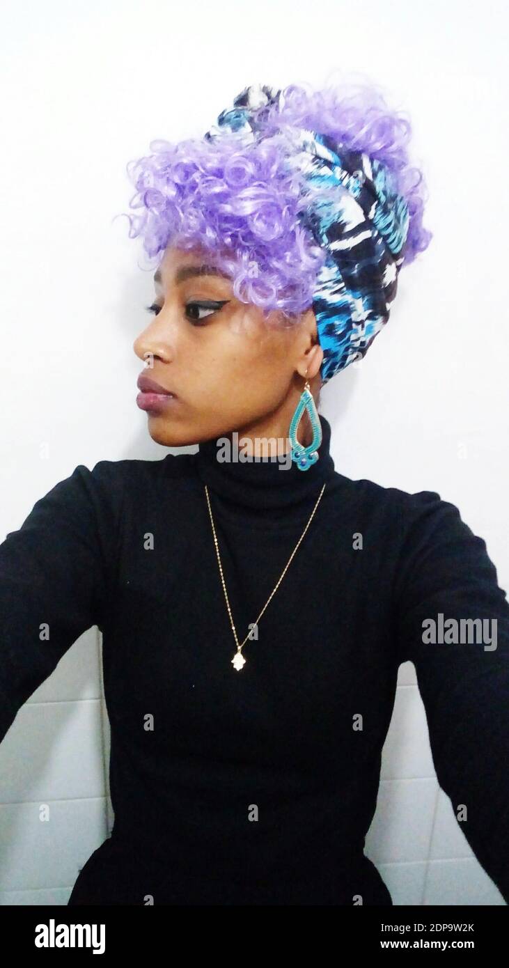 Mujer joven reflexiva con pelo morado teñido contra la pared Fotografía de  stock - Alamy