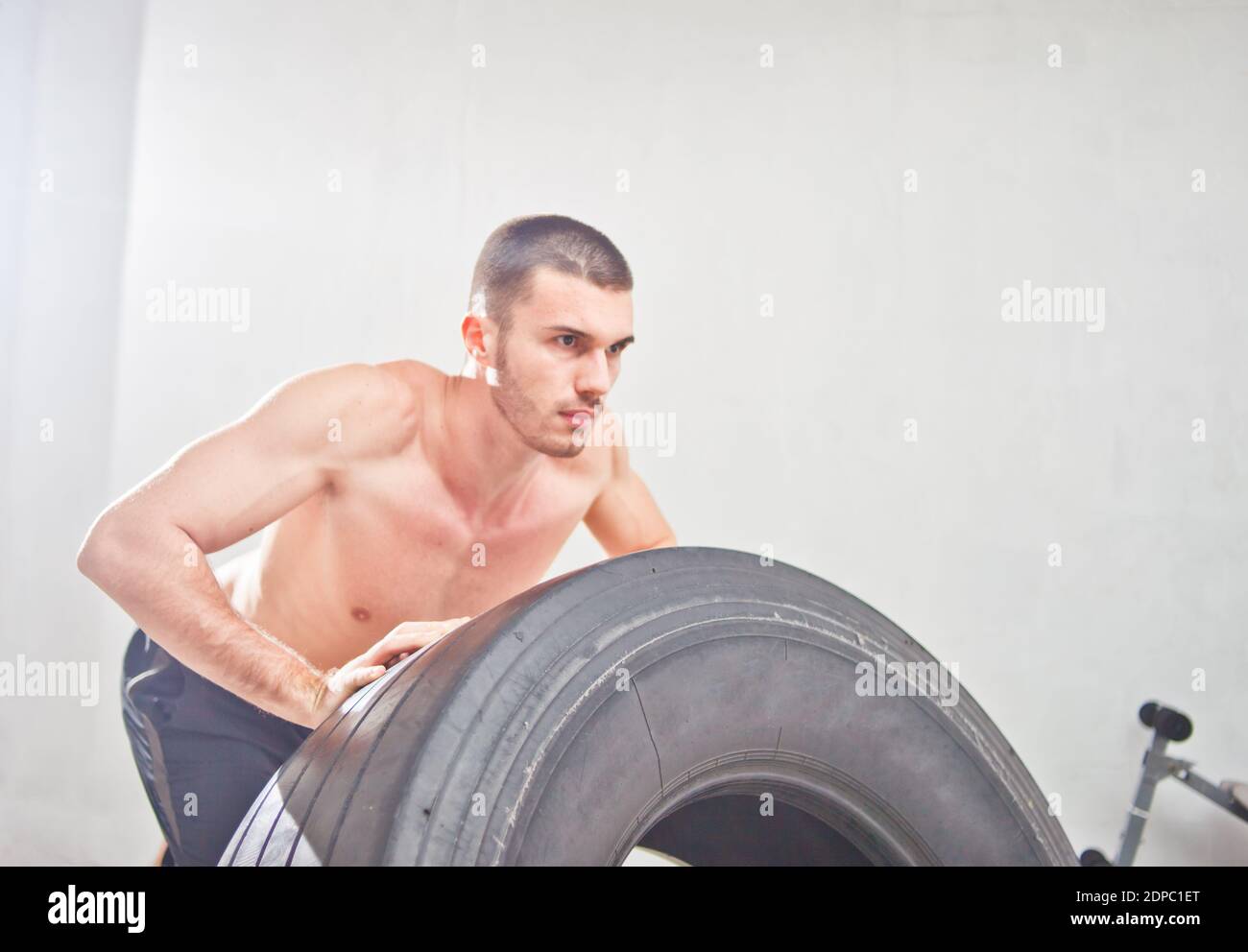 Entrenamiento Crossfit - hombre volteando neumático en gimnasio Fotografía  de stock - Alamy