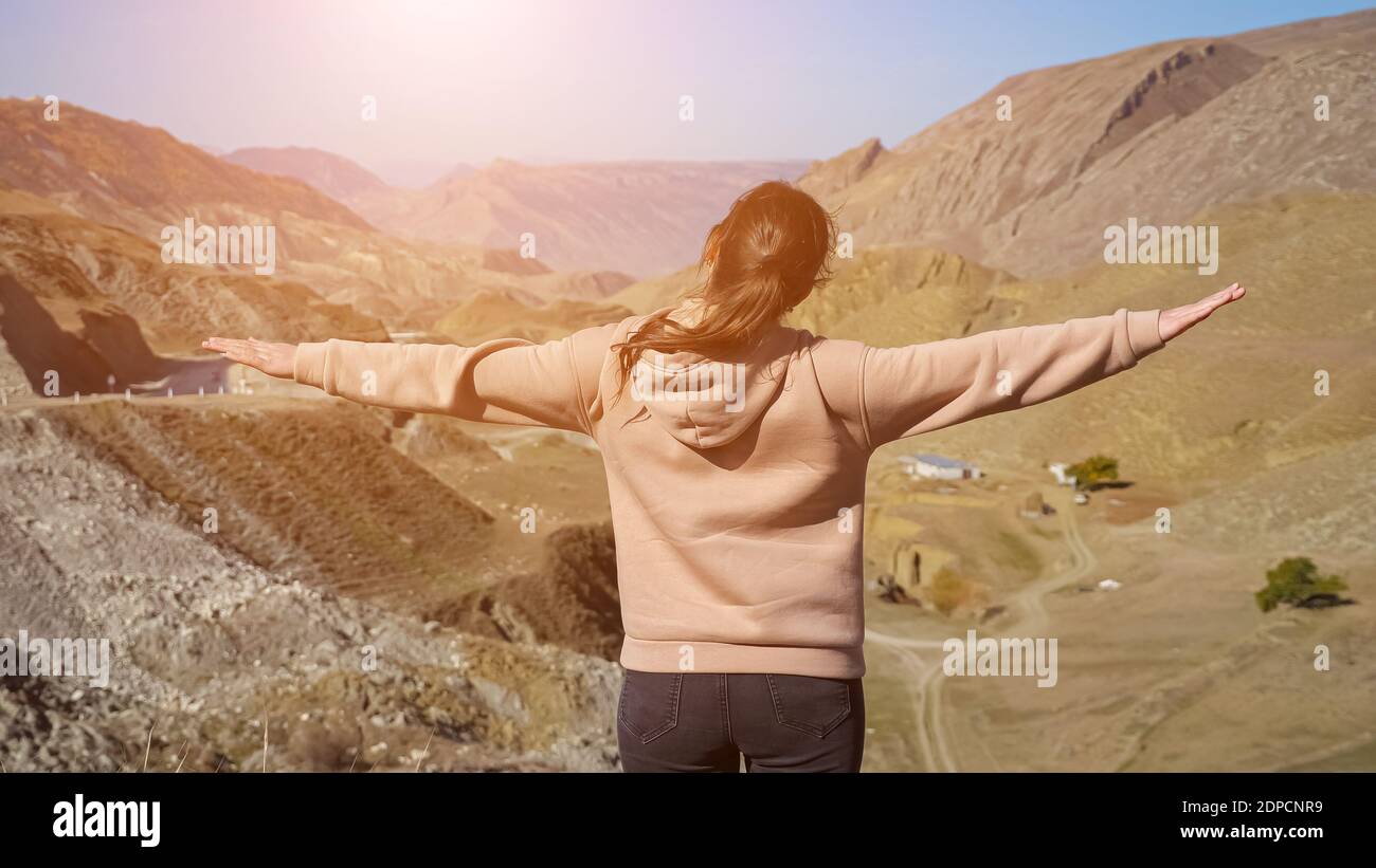 Mujer en una sudadera de color beige y rosa con capucha contra una roca en  las montañas Fotografía de stock - Alamy