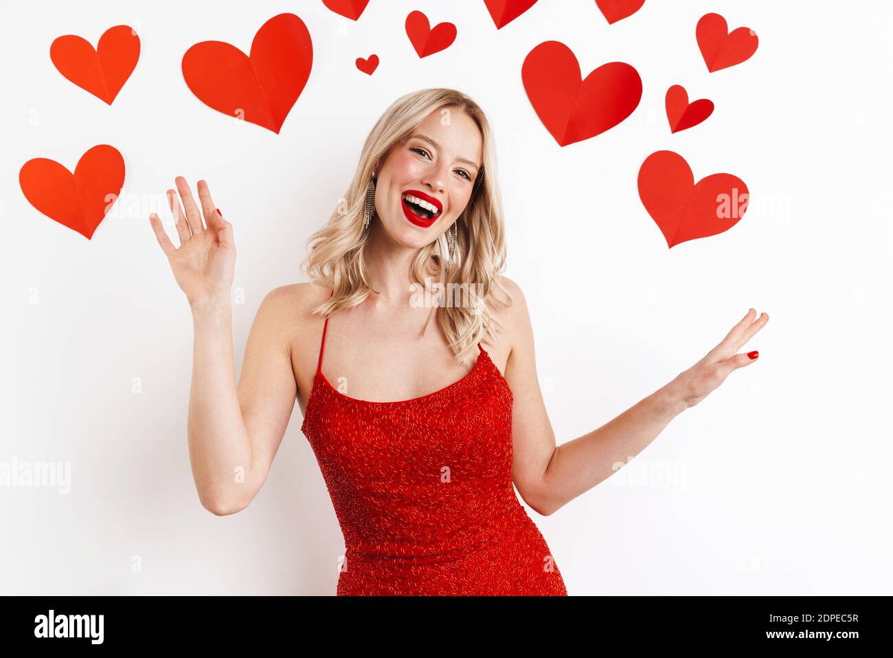 Imagen de una joven rubia feliz mujer con vestido rojo con lápiz labial  rojo aislado sobre fondo blanco con corazones Fotografía de stock - Alamy