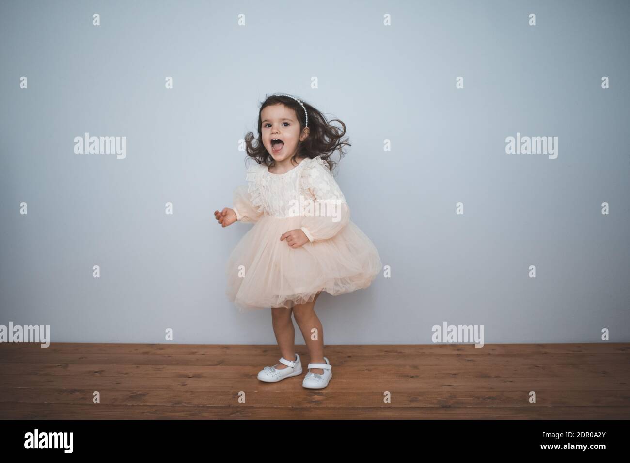 Feliz niña de 2-3 años de edad con vestido princesa en la habitación de  cerca. Mirando la cámara. La infancia. Fiesta de cumpleaños. Felicidad  Fotografía de stock - Alamy