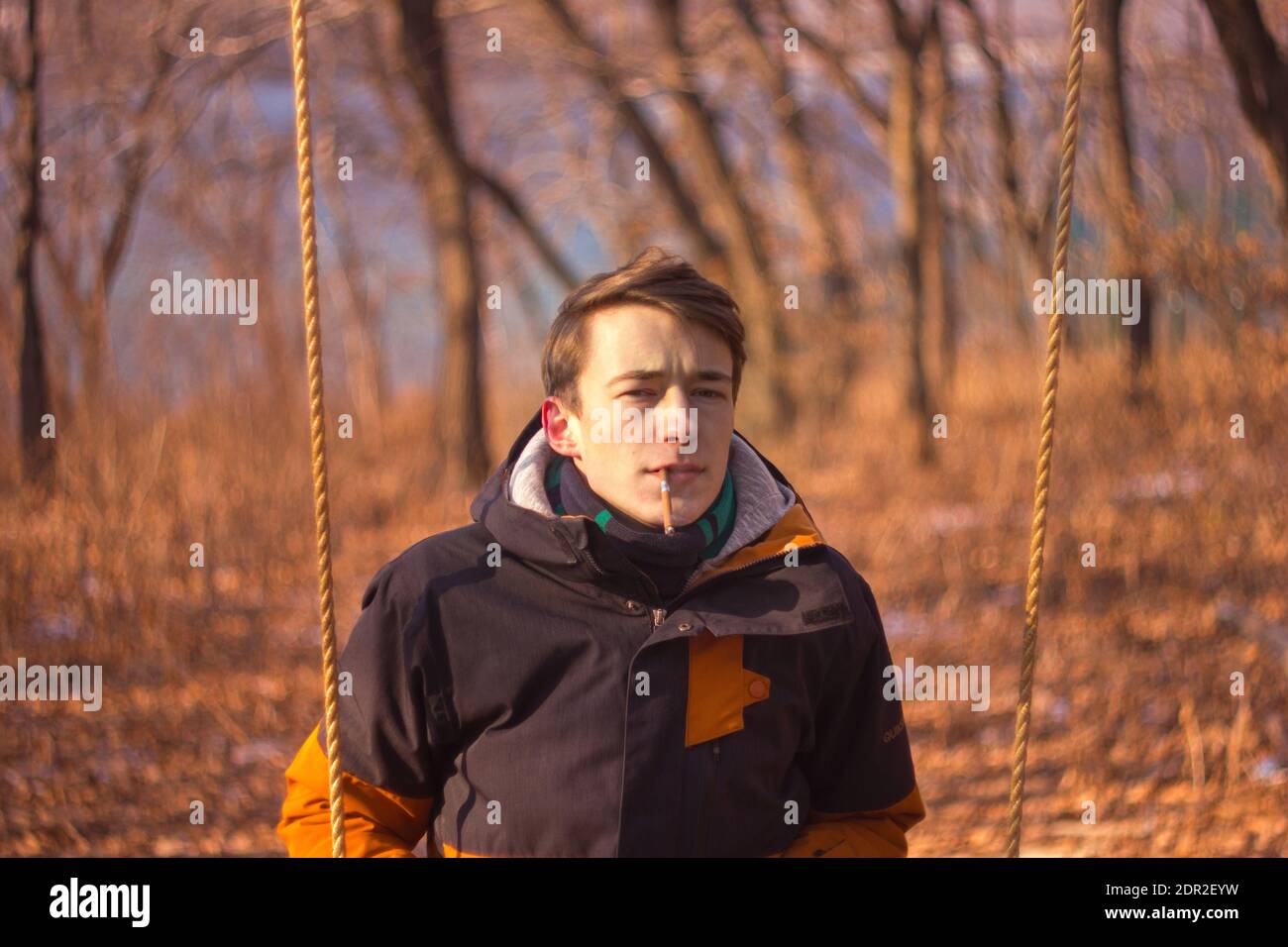 Retrato del joven Fumando Cigarrillo contra los árboles Foto de stock