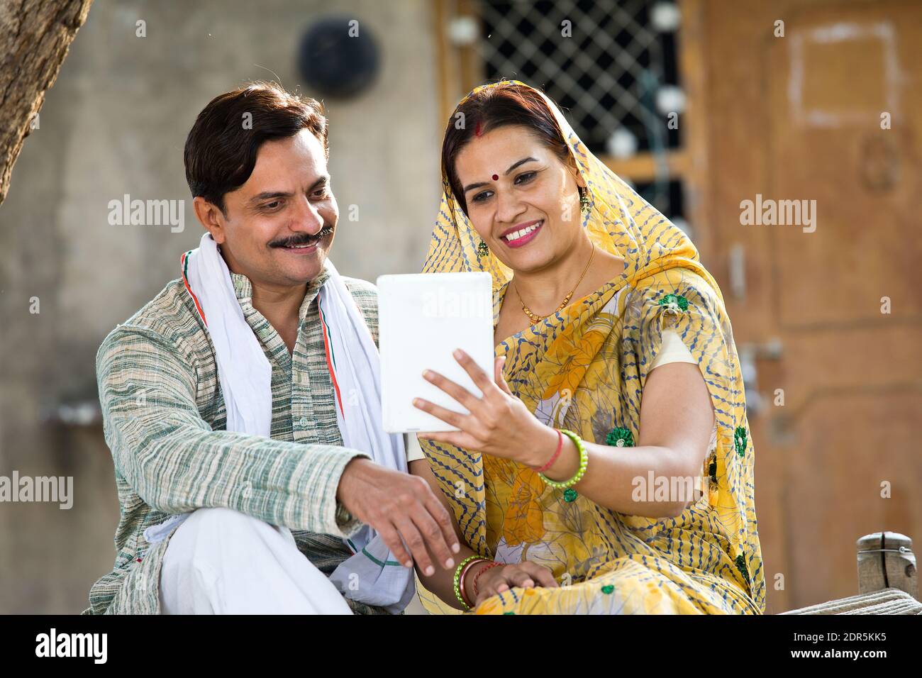 Mujer rural India y marido utilizando tabletas digitales en la aldea Foto de stock