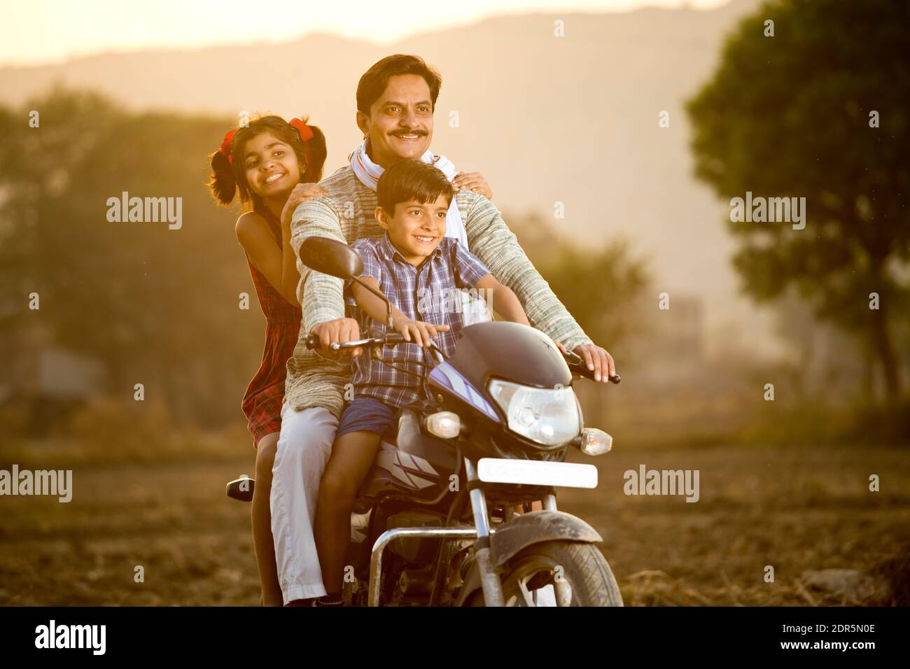 Feliz campesino indio con niños en motocicleta Foto de stock