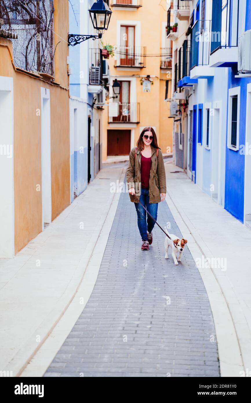 Duración completa de la mujer con perro en la ciudad Foto de stock