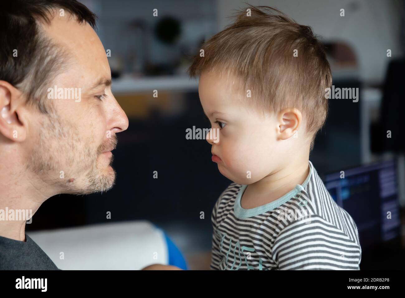 Vista lateral del hombre adulto medio mirando a un hijo con síndrome de  Down Fotografía de stock - Alamy