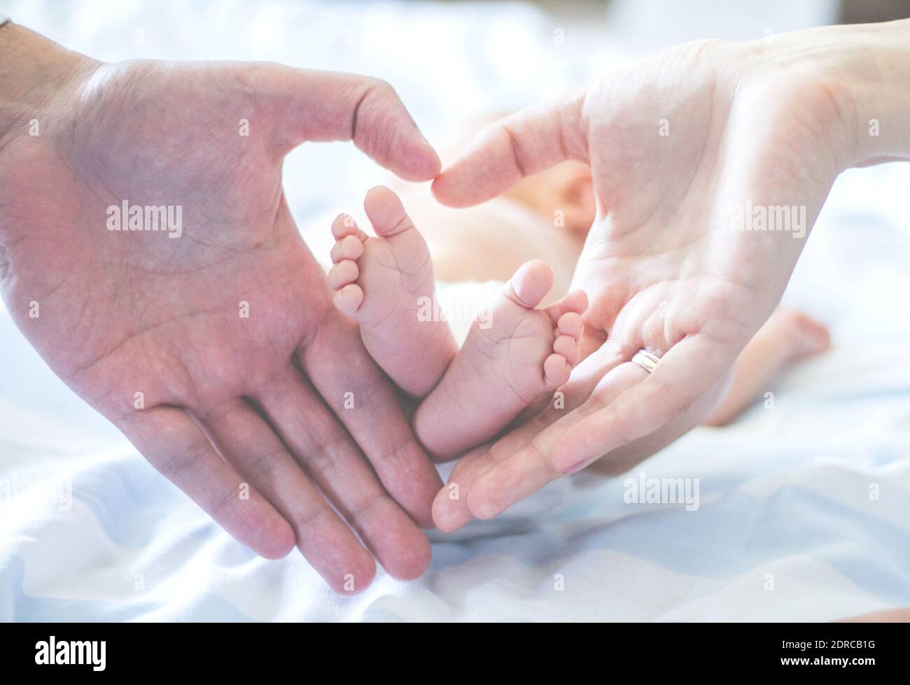 Manos de pareja recortadas con bebé en casa Fotografía de stock - Alamy