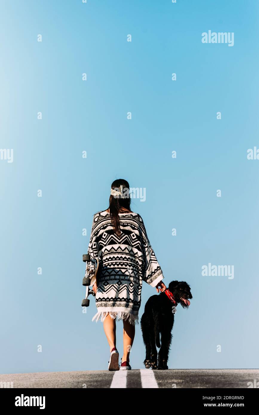 Vista trasera de la mujer con perro contra cielo claro Fotografía de stock  - Alamy