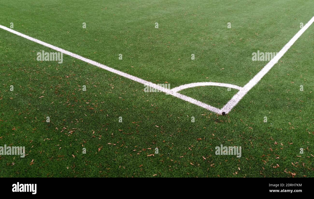 Av Fotbollsplan grönt konstgräs med i vitt hörncirkelmarkering linjer med. Foto de stock