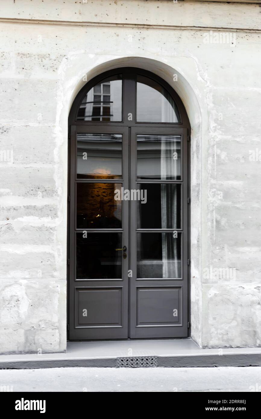 excursionismo Duquesa Eficiente Nueva puerta de doble hoja de madera gris arqueada. Puerta de madera -  entrada. Antigua puerta gris en pared de piedra en casa de hormigón París  Francia Fotografía de stock - Alamy