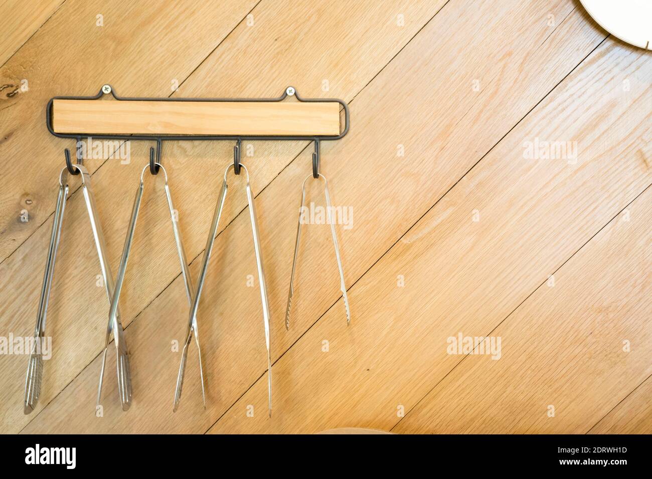 Pinzas para servir colgadas en la pared Fotografía de stock - Alamy